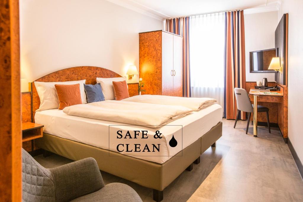ein Hotelzimmer mit einem Bett mit einem Safe und einem sauberen Schild darauf in der Unterkunft BARDOLINO Fine.Food.Hotel in Nürnberg