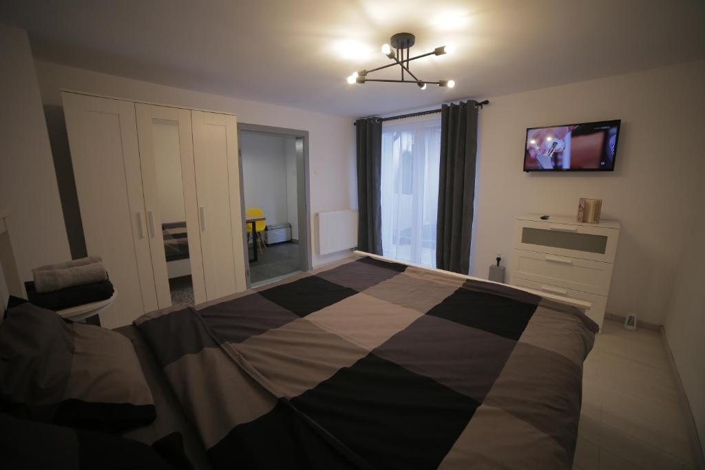 a bedroom with a bed and a tv on the wall at Citadella House Targu Mures in Târgu-Mureş