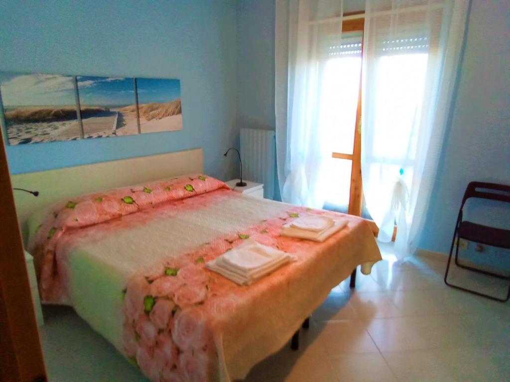 カッサーノ・デッレ・ムルジェにあるCasaSylviaのベッドルーム1室(ピンクの花が咲く大型ベッド1台付)