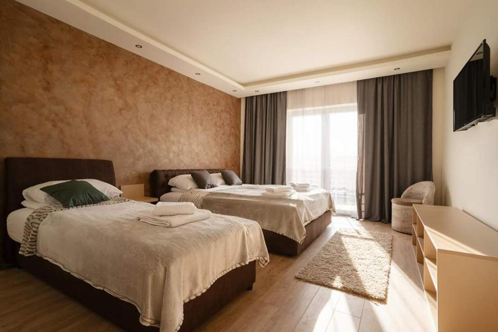 a hotel room with two beds and a television at Garni hotel Mali predah - novi deo in Knjazevac.