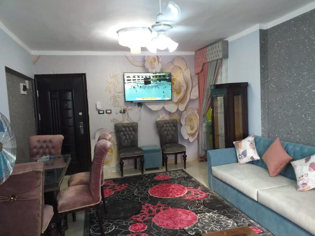 een woonkamer met een bank en stoelen en een tv bij Sea View Sidi Bisher - in front of Sidi Bisher Mosque - Best Choice for Families - only Families- No Solo - No unmarried please in Alexandrië