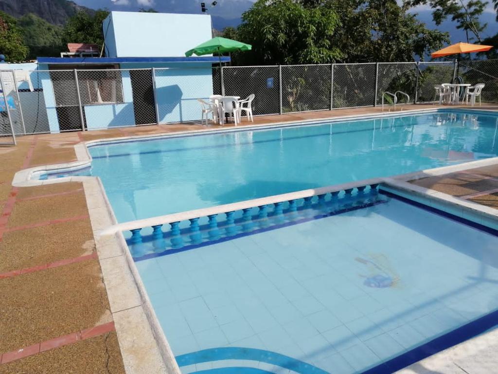 a large swimming pool with blue water at Finca Campestre Piscina Privada Anapoima in Anapoima