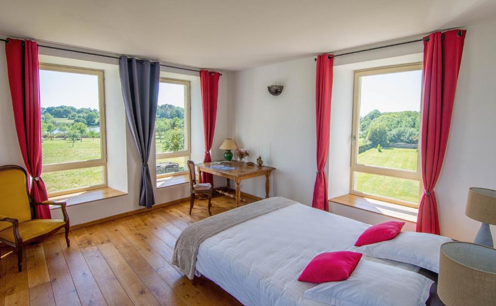 a bedroom with two beds and two windows at Domaine de kerbillec in Theix