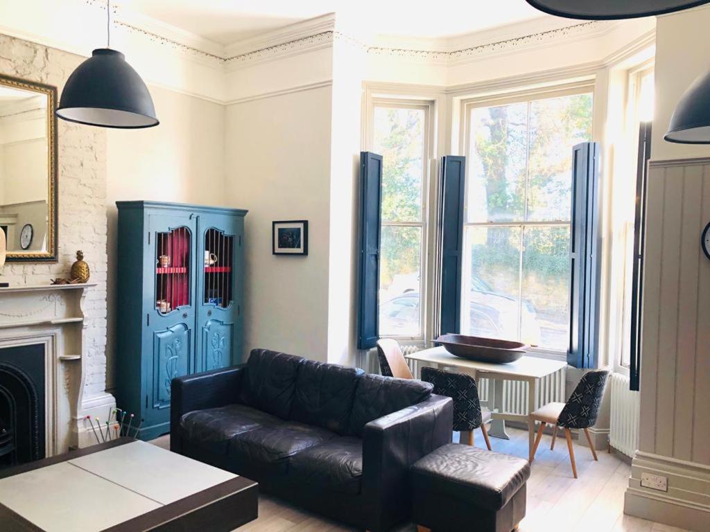 a living room with a leather couch and a blue cabinet at Seaside Escape - gorgeous 2 bed apartment in St-Leonards-on-Sea in Hastings