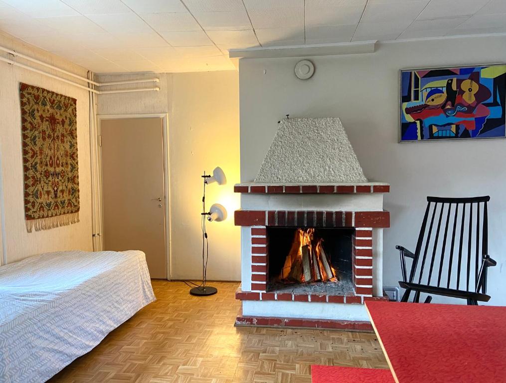 1 dormitorio con chimenea en una habitación con 1 cama en Tilava huoneisto puutarhanäkymällä en Kankaanpää