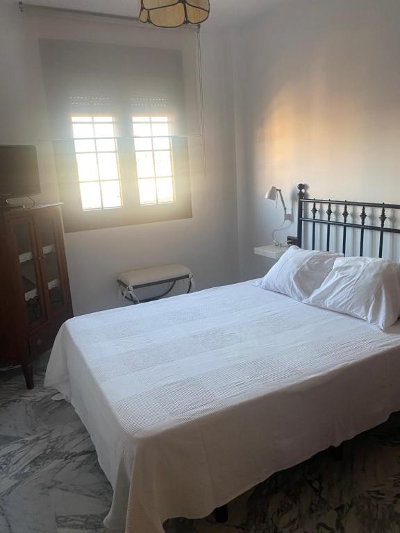 サンルーカル・デ・バラメダにあるRondaのベッドルーム(大きな白いベッド1台、窓付)