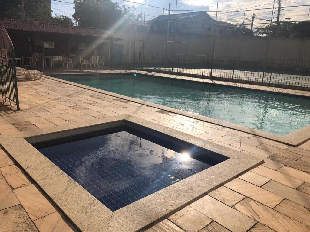 una piscina vuota in un cortile con il sole splendente di Vivendas de Iguaba a Iguaba Grande