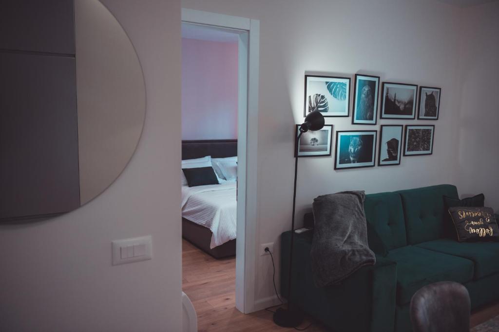 een woonkamer met een groene bank en een bed bij TAM Serviced Apartments City Center No2 in Tirana