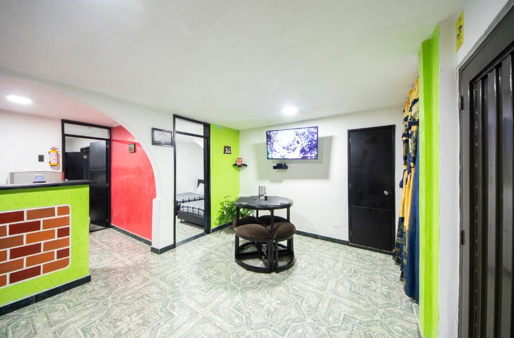 een kamer met groene en rode muren en een tafel bij Casa Quindio in Armenia