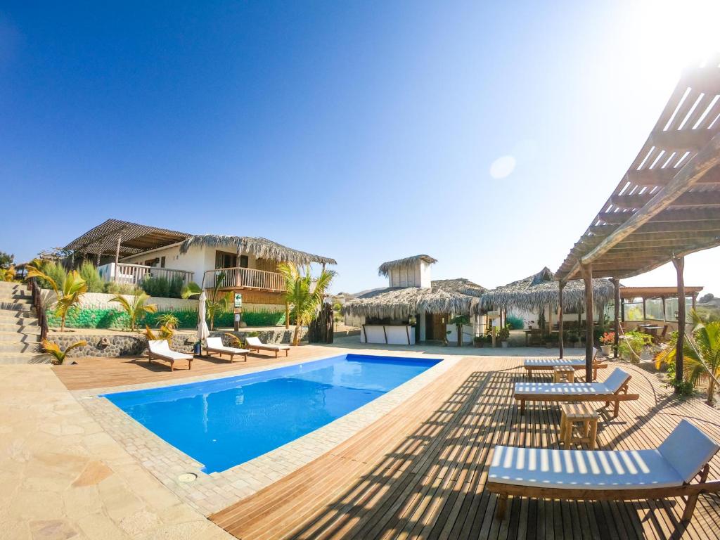un resort con piscina, sedie e ombrelloni di Villa Mia Boutique a Los Órganos