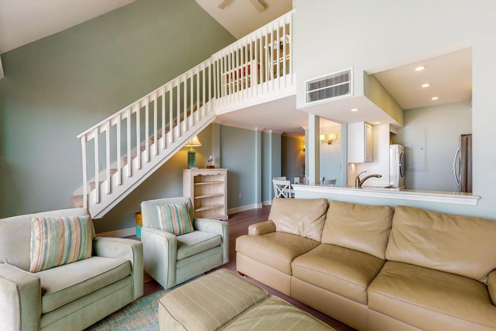 a living room with a couch and a staircase at Sea Colony Chesapeake House IV in Bethany Beach