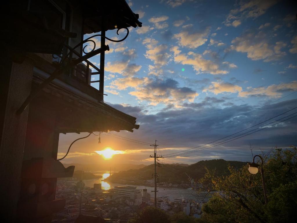 vista para o pôr-do-sol sobre uma cidade em Onomichi Guest House Miharashi-tei em Onomichi