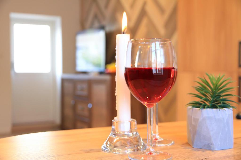 a glass of wine and a candle on a table at Saga Caves Straen in Stavanger