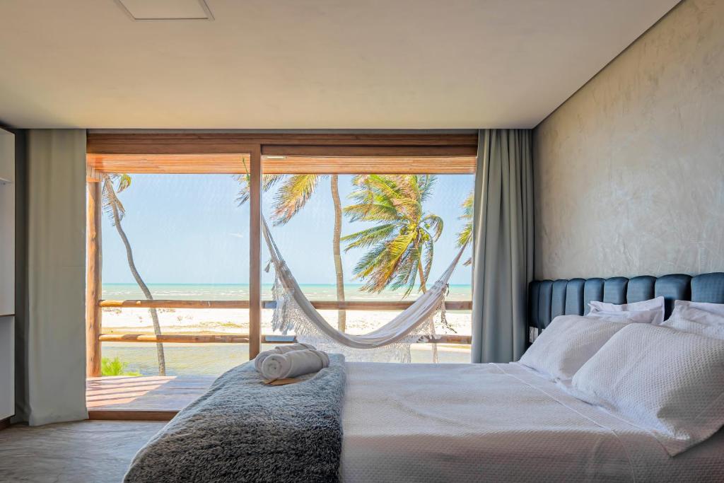 a bedroom with a bed and a view of the ocean at Pousada Kiriri in Itarema