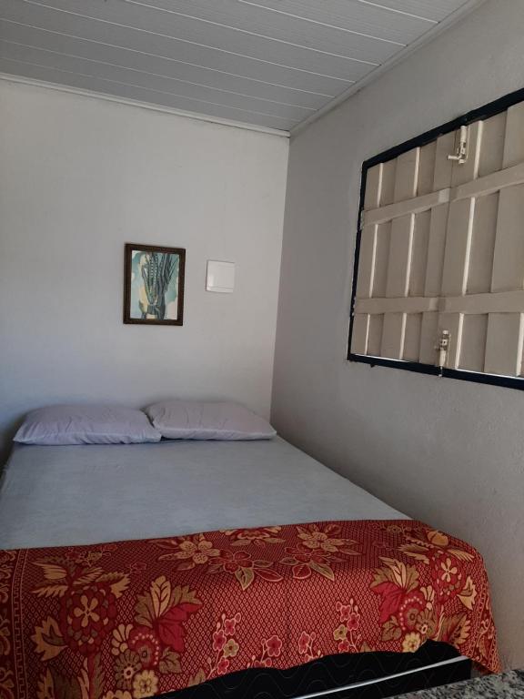 Habitación pequeña con cama y ventana en Estância Morro Do Frota en Pirenópolis