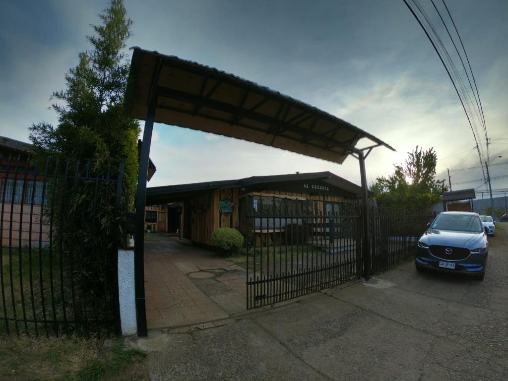 una puerta con un coche estacionado frente a un edificio en Hostal Los Guindos, en Temuco