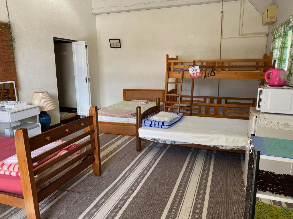 Pokój z 2 łóżkami piętrowymi i lodówką w obiekcie M3 w mieście Uruma