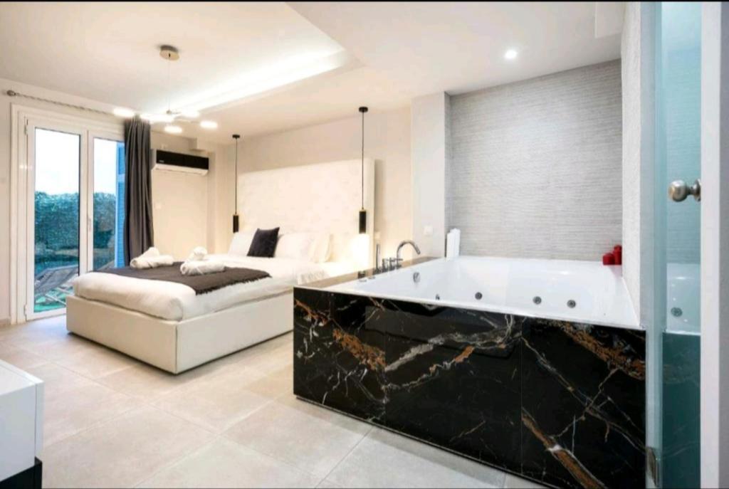 een badkamer met een bad en een bed in een kamer bij DELUXE ROMANTIC JACUZZI in Athene