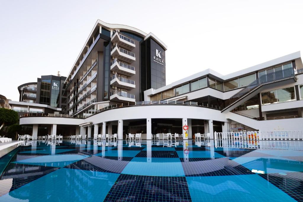 un edificio con piscina frente a él en Kaila Beach Hotel - All Inclusive, en Alanya