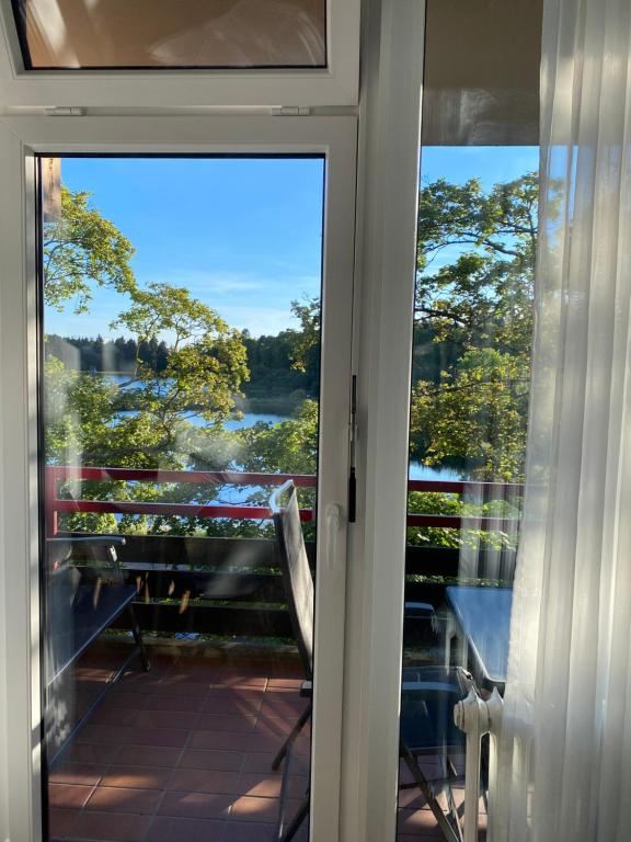 a door to a balcony with a view of the water at Seeblickapp. „Eure Auszeit“ in Goslar
