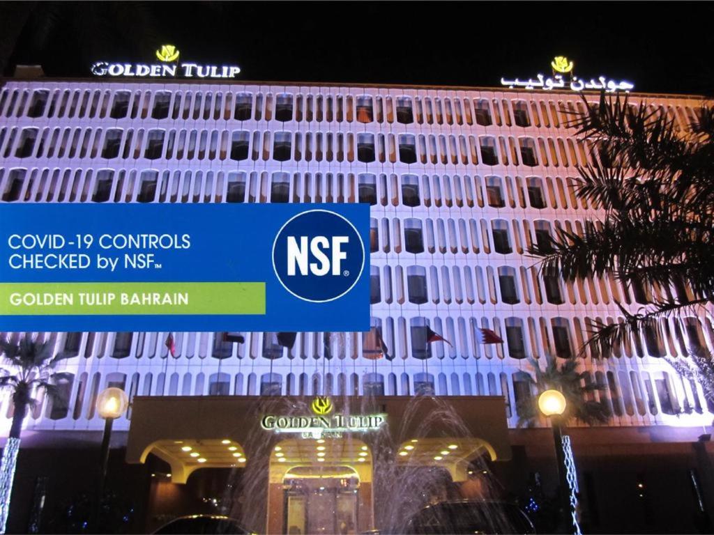 a building with a ntec sign in front of it at Golden Tulip Bahrain in Manama
