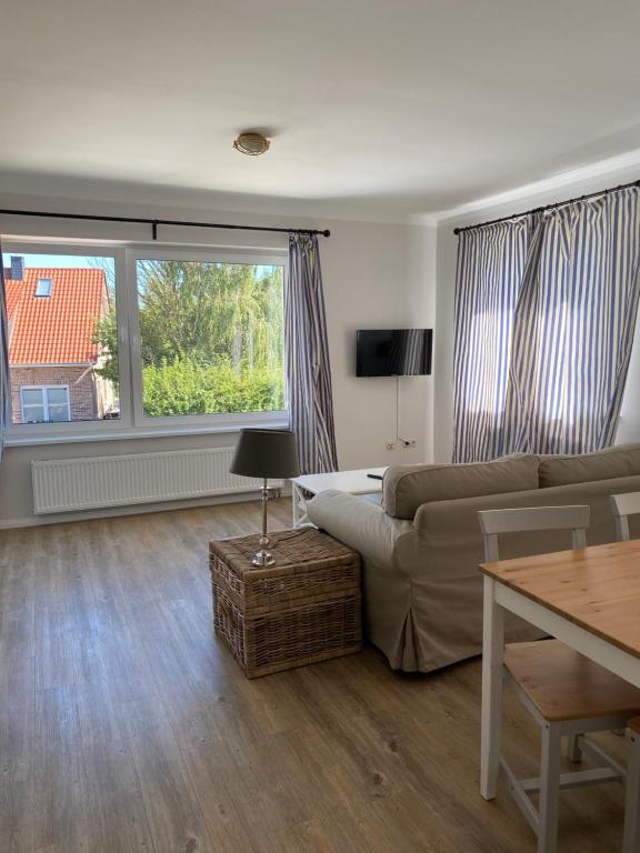 ein Wohnzimmer mit einem Sofa und einem Tisch in der Unterkunft Hotel & Ferienunterkünfte Hus Seeblick in Fehmarn