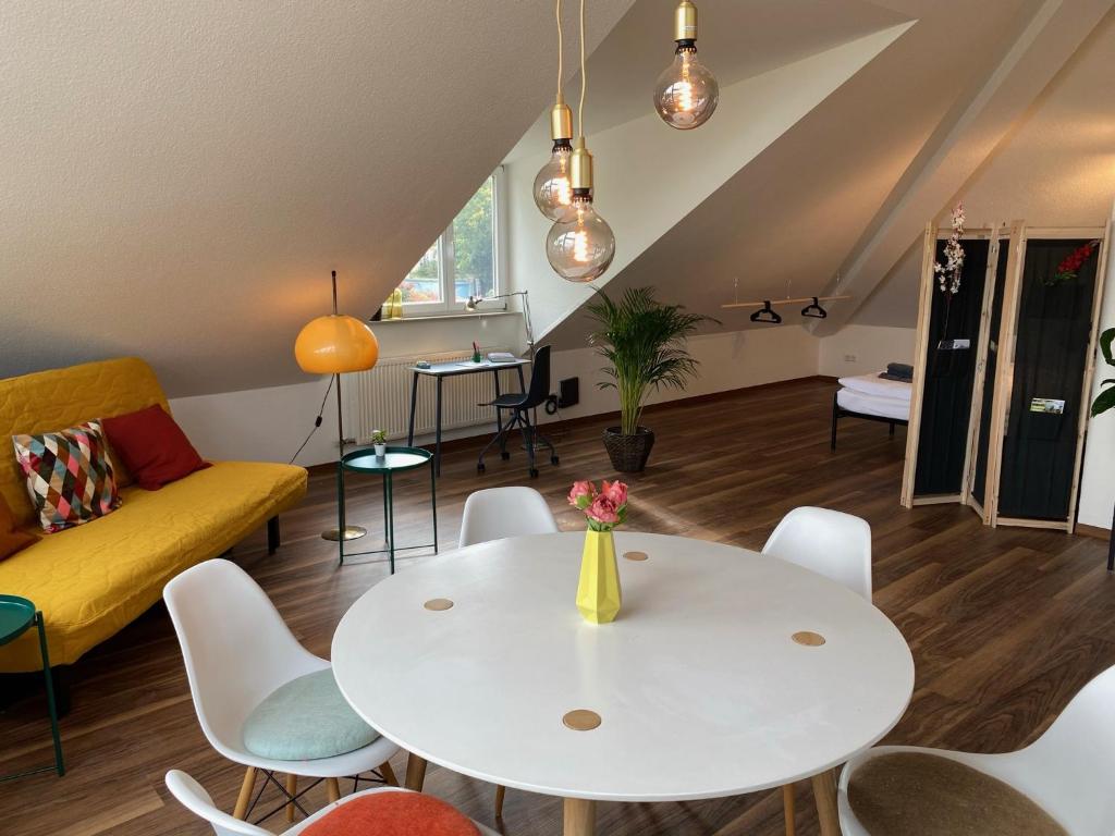 Sonnige Wohnung im Herzen von Marbach في مارباخ أم نيكار: غرفة معيشة مع طاولة وكراسي بيضاء