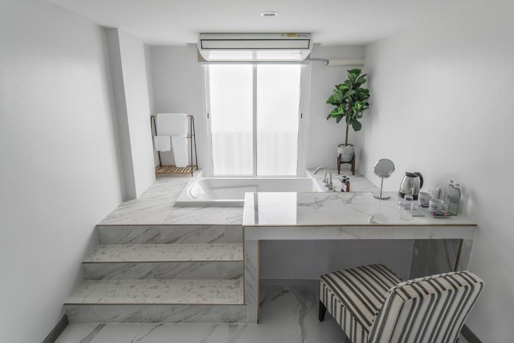 a bathroom with a sink and a bath tub at Tree Tara hotel in Lampang