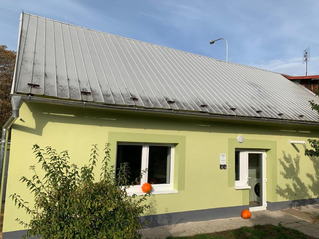 una casa verde con techo solar en Apartmány Kosmonosy, Hradištská 193, en Mladá Boleslav