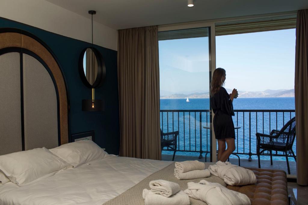 
a man standing in front of a bed in a hotel room at Hotel La Pietra Restaurant & Spa in LʼÎle-Rousse
