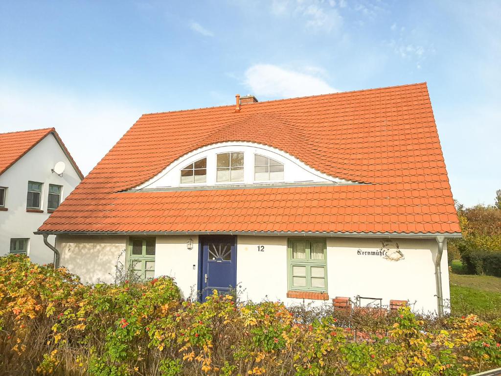 ein weißes Haus mit orangefarbenem Dach in der Unterkunft Kornmühle Doppelzimmer Mühlenstein in Mellenthin