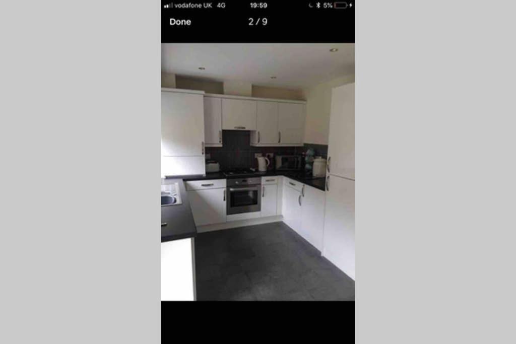 uma cozinha com armários brancos e um forno com placa de fogão em Kingseat 3 Bed Home With Fast Fibre WiFi &Parking em Newmacher