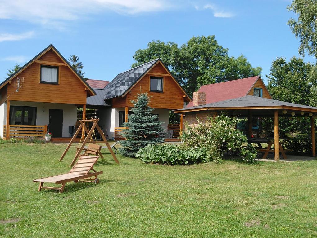 a house with a swing in front of it at Domki u Goni in Karwieńskie Błoto Pierwsze
