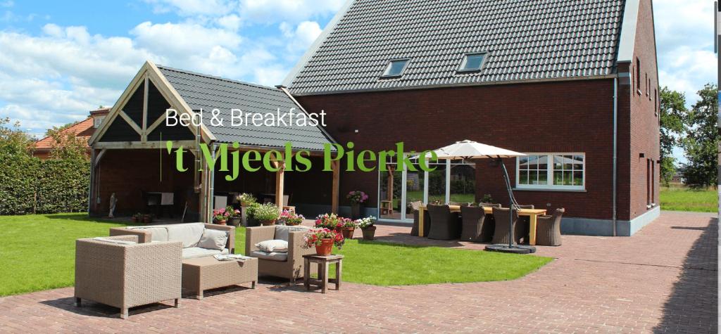 a building with chairs and tables in front of it at B&B 't Mjeels Pierke in Meerle