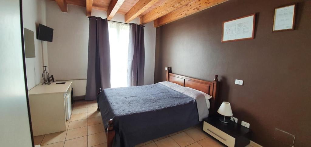 um quarto com uma cama e uma grande janela em IL Borgo em Módena