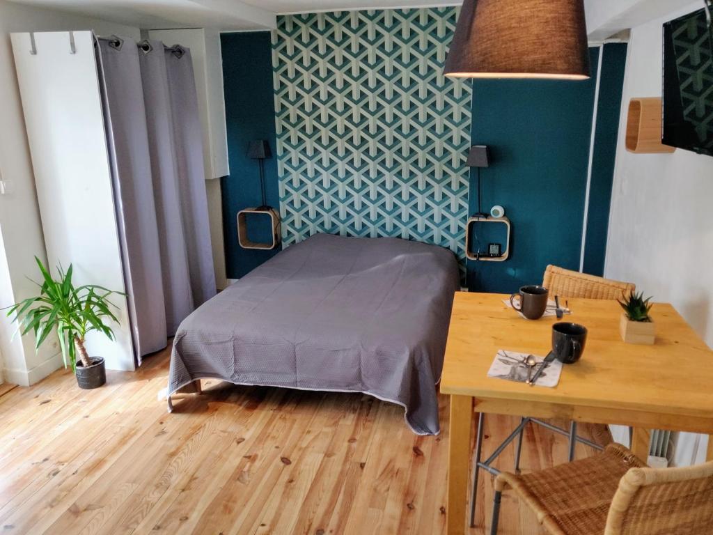 een slaapkamer met een bed en een tafel met een tafel bij Halte du Vert Coteau in Chevinay