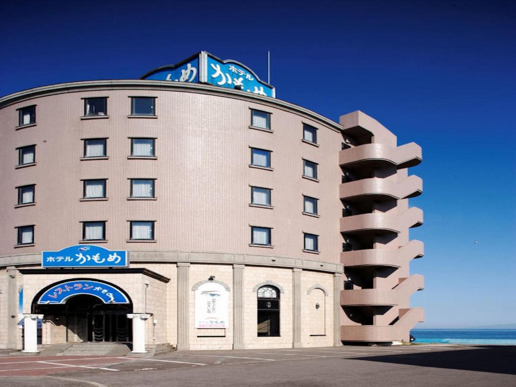 a large building with a sign on top of it at Seaside Hotel Kamome in Hakodate