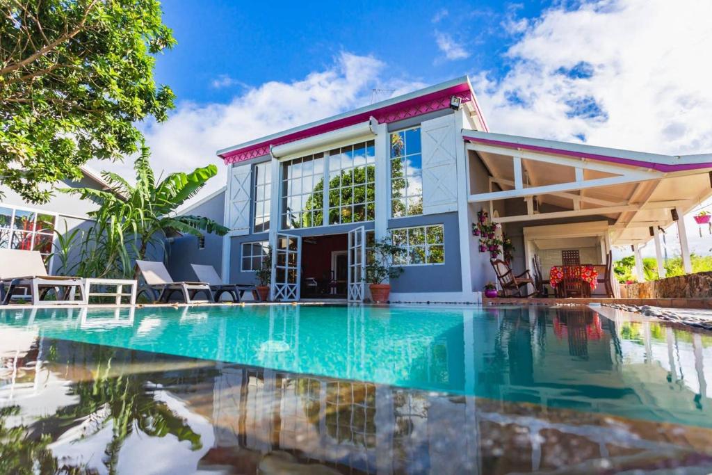 una casa con piscina frente a ella en Villa de 2 chambres a Sainte Rose a 500 m de la plage avec vue sur la mer piscine privee et jardin clos, en Sainte-Rose
