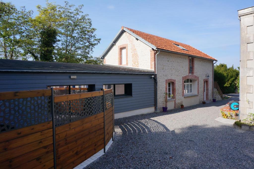 a house with a wooden gate and a garage at Domaine du Moulin à Vent - Gîte & SPA in Saint-Florent-sur-Cher