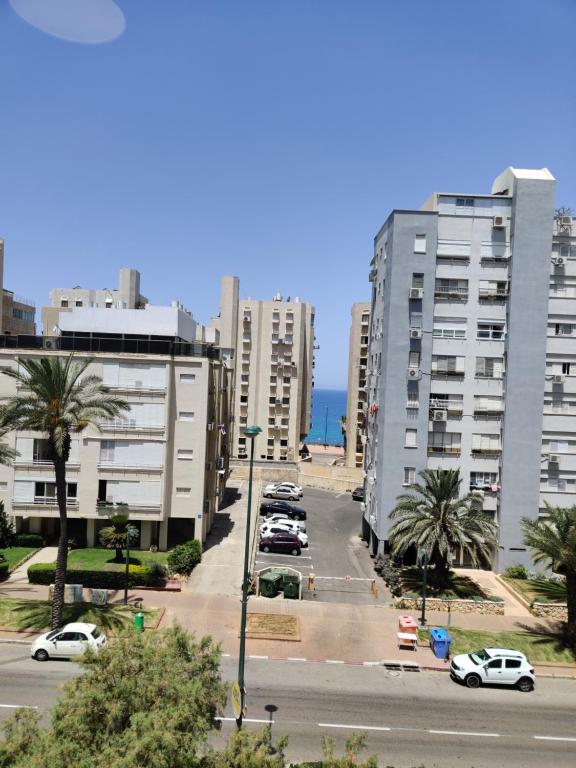 a city street with cars parked in front of tall buildings at Migdal Luxury Suites Netanya J29 in Netanya