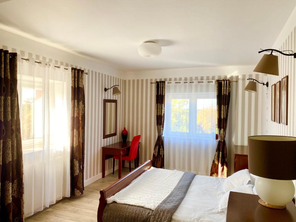 1 dormitorio con cama, escritorio y ventana en Słupsk forest PREMIUM LOVE APARTAMENT M5 - Kaszubska street 18 - Wifi Netflix Smart TV50 - double bathtub - up to 4 people full - pleasure quality stay, en Słupsk