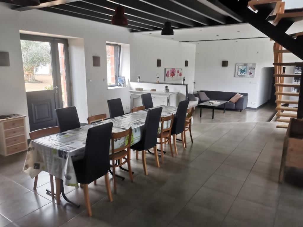 una sala da pranzo con tavolo e sedie di maison du bonheur de la basse biguerie proche du zoo de la flèche a Saint-Jean-de-la-Motte