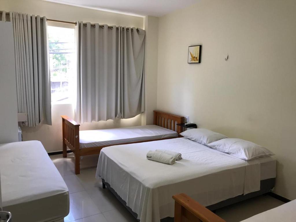 1 dormitorio con 2 camas y ventana en Hotel Italia Beach, en Fortaleza