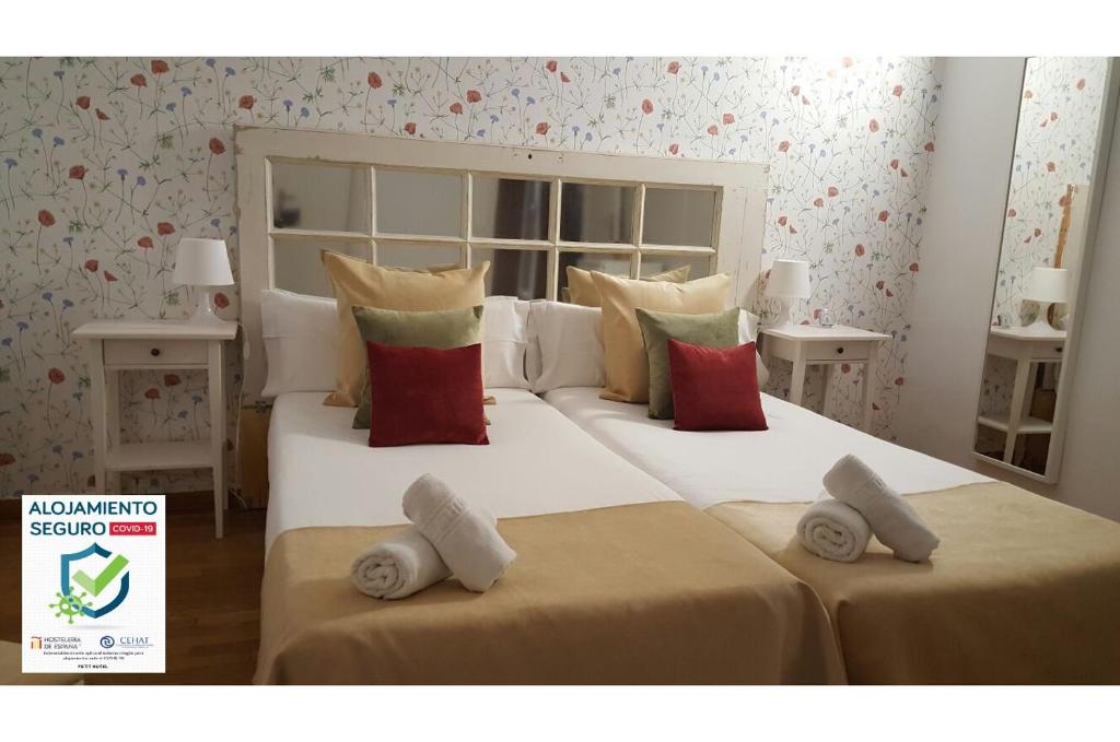 two beds in a bedroom with two pillows at Petit Hotel in Barcelona