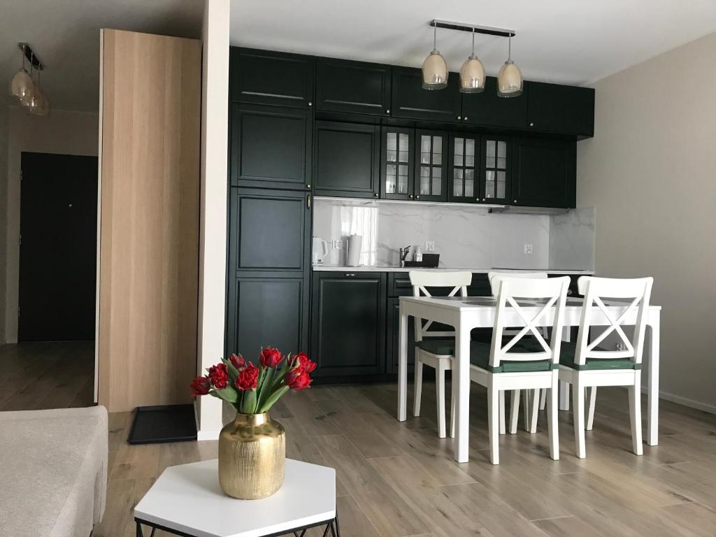 a kitchen and living room with a table and chairs at Baltica Sea Apartment II in Gdańsk