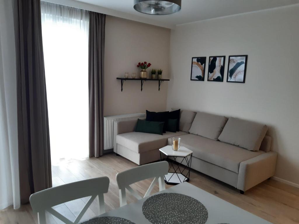 een woonkamer met een bank en een tafel bij Baltica Sea Apartment II in Gdańsk