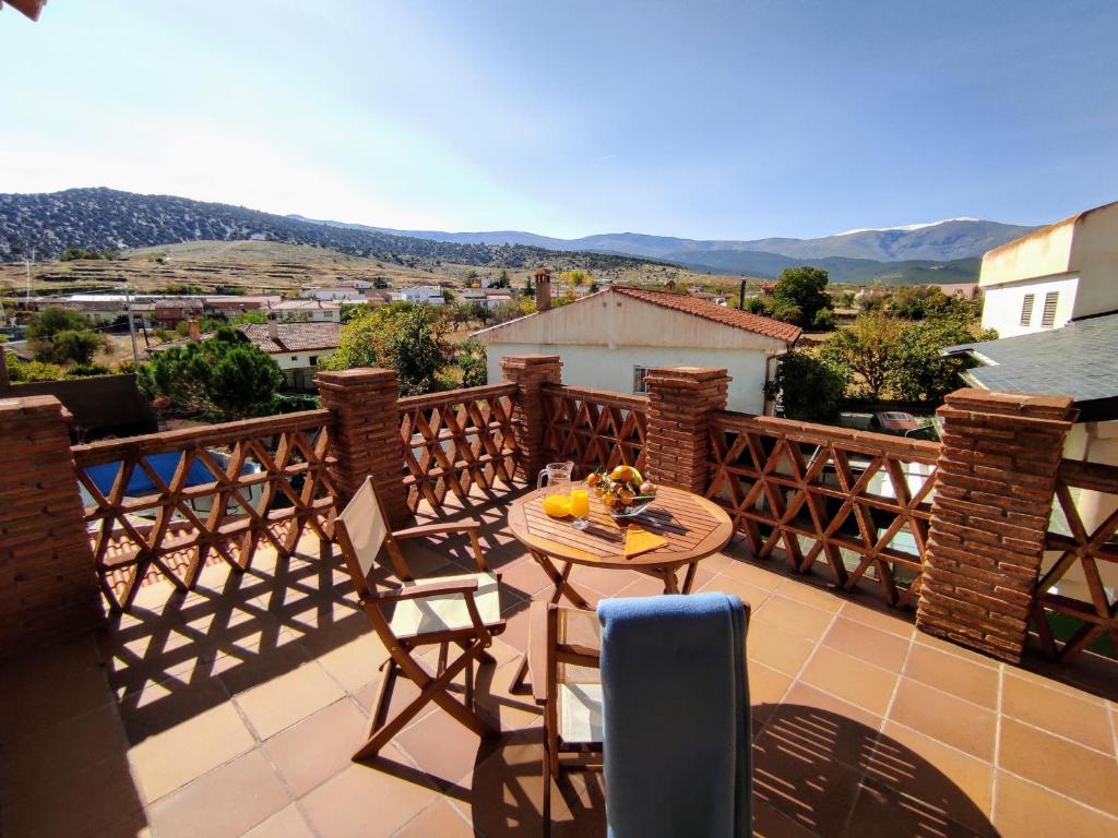 a patio with a table and chairs on a balcony at Casa Rural Alquife in Alquife