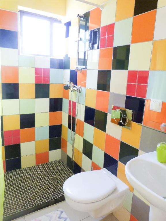 a colorful bathroom with a toilet and a sink at Casa do Lado in Carrapateira