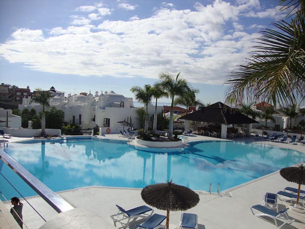 a large blue swimming pool with chairs and umbrellas at Luxury Vila Adeje Paradise in Adeje