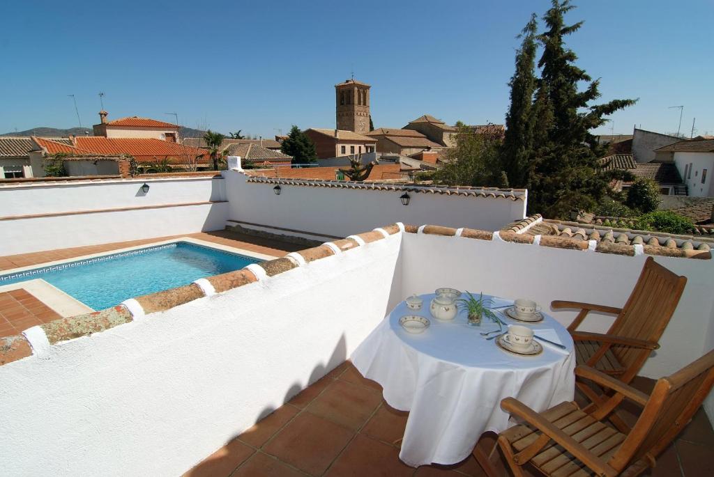 a table and chairs on a balcony with a swimming pool at casa rural los corrales Totanes puy du Fou España in Totanés